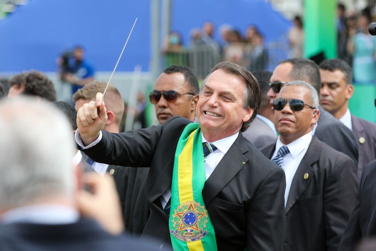 Fabio Rodrigues Pozzebom/Agênci O presidente Jair Bolsonaro,quebra o protocolo  desce do palanque, pega uma batuta e faz gestos de maestro ao se aproximar a pé, das arquibancadas onde fica o público na Esplanada dos Ministérios